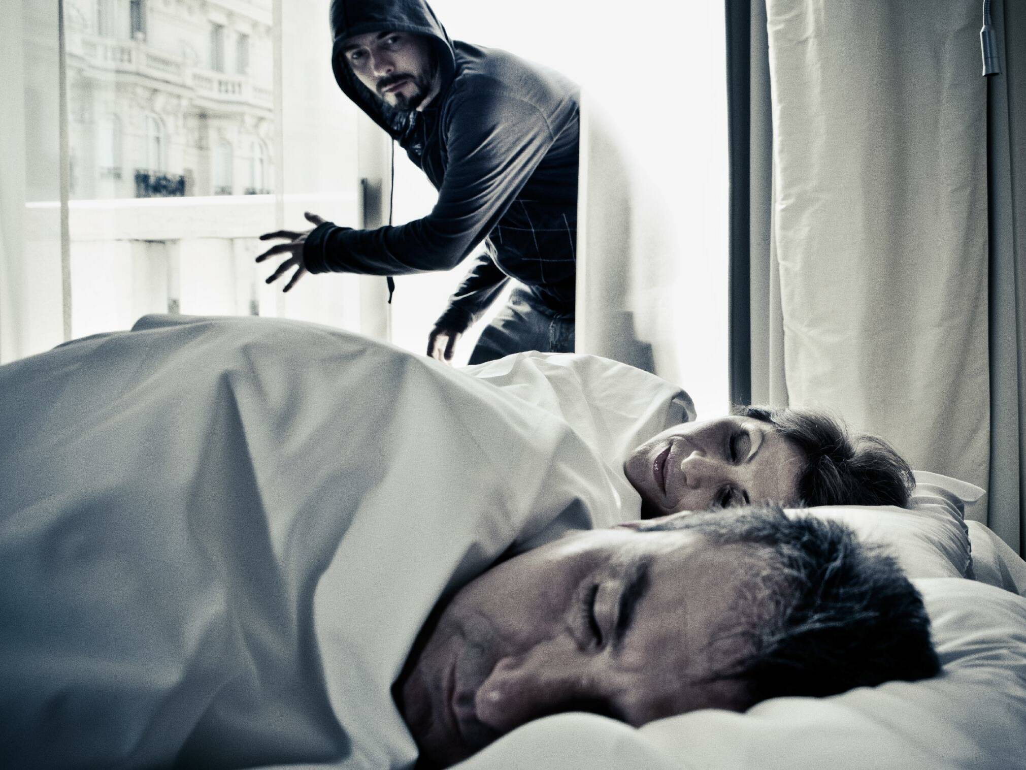 Mann und Frau schlafen, Einbrecher im Zimmer