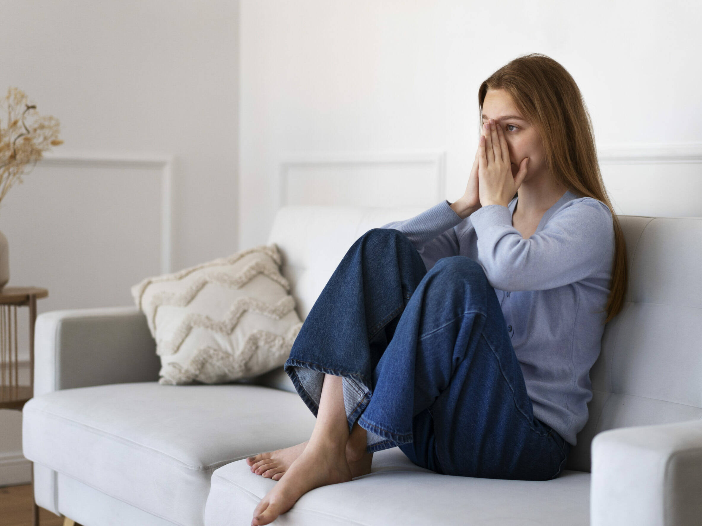 Frau sitzt auf dem Sofa ist schockiert