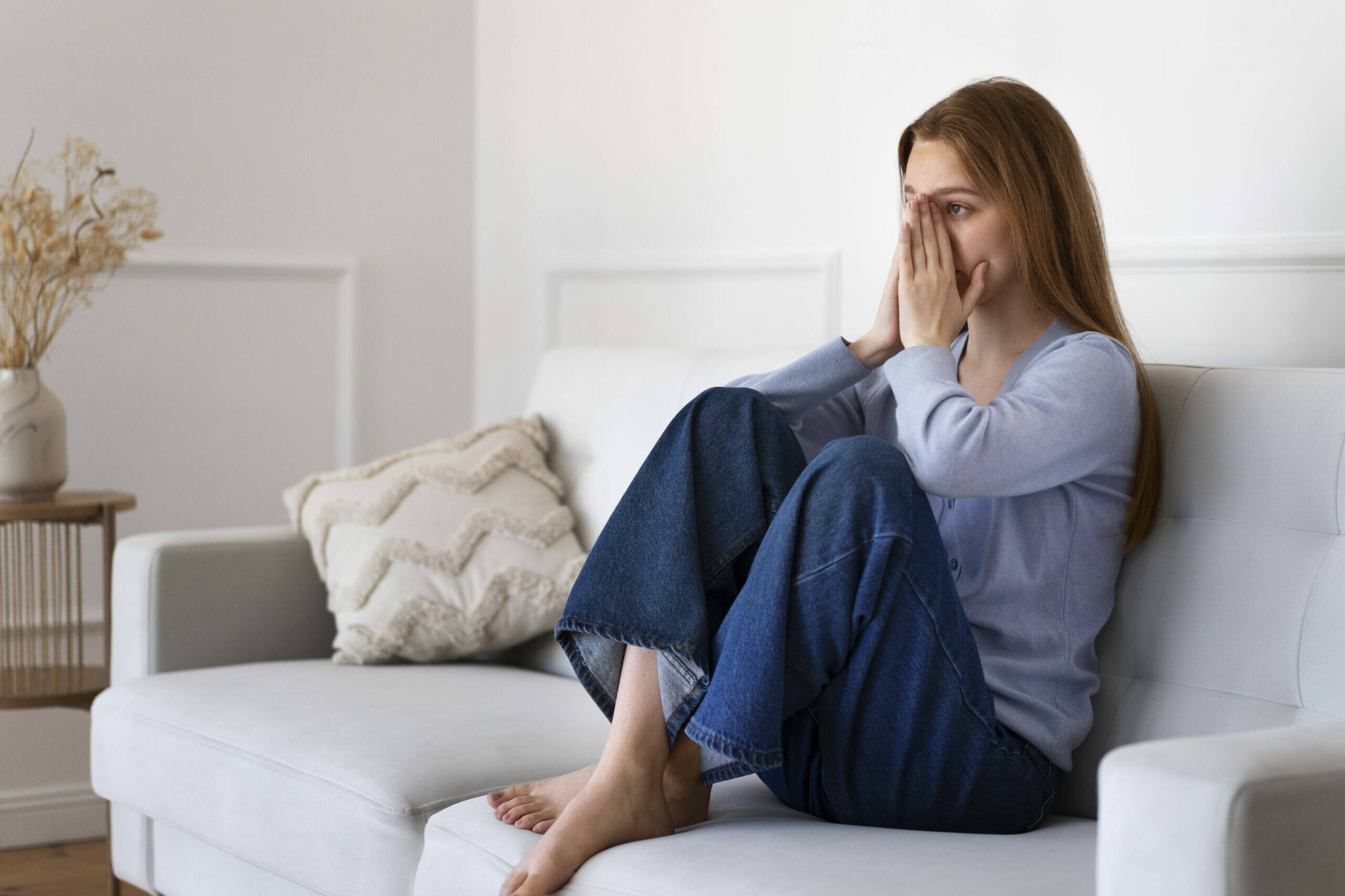 Frau sitzt auf dem Sofa ist schockiert